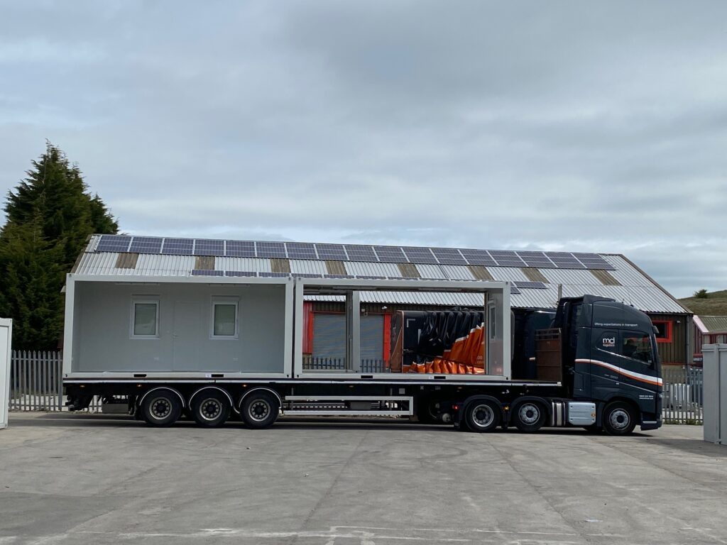 Modular unit with solar panels on a flatbed trailer, ready for delivery