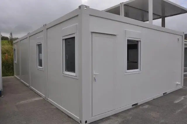 Exterior of a modular building with multiple windows, set in an outdoor environment