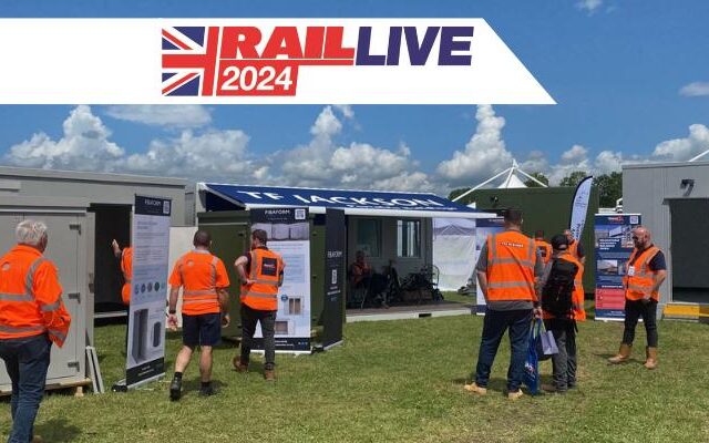 Attendees in orange vests visiting TF Jackson booth at Rail Live 2024.