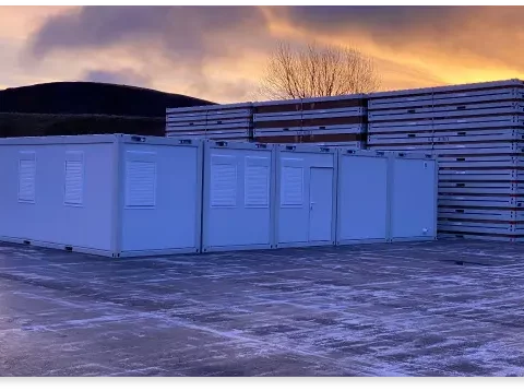 Storage containers lined up in an outdoor lot at dusk